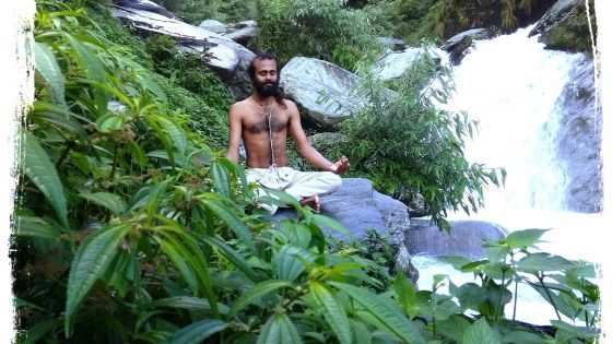 yoga teacher is meditating at the waterfall