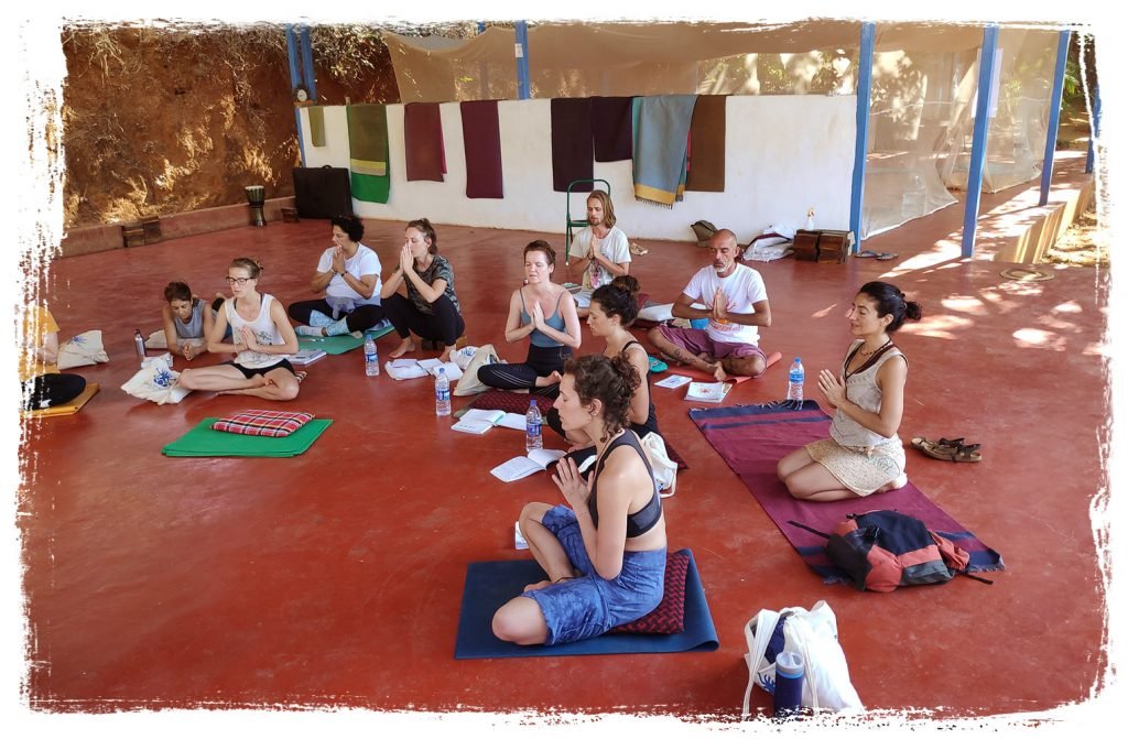 theoryclass | Yoga Teacher Training in India at Shree Hari School | Certified YTT course yoga students in lotus pose, praying