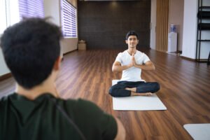 Yoga instructor meditating with student in gym | Yoga Teacher Training in India at Shree Hari School | Certified YTT course